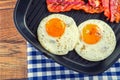 Ham and Egg. Bacon and Egg. Salted egg and sprinkled with black pepper. Grilled bacon, two eggs in a Teflon pan Royalty Free Stock Photo