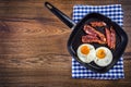 Ham and Egg. Bacon and Egg. Salted egg and sprinkled with black pepper. Grilled bacon, two eggs in a Teflon pan Royalty Free Stock Photo