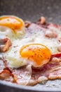 Ham and Eggs. Bacon and Eggs frying on ceramic pan. Salted egg and sprinkled with red pepper. English breakfast