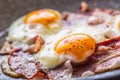 Ham and Eggs. Bacon and Eggs frying on ceramic pan. Salted egg and sprinkled with red pepper. English breakfast