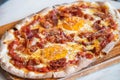Ham and Eggs Breakfast style pizza on wooden platter Royalty Free Stock Photo