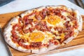 Ham and Eggs Breakfast style pizza on wooden platter Royalty Free Stock Photo