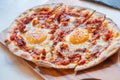 Ham and Eggs Breakfast style pizza on wooden platter Royalty Free Stock Photo