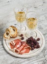 Ham, grapes, ciabatta bread and two glasses with white wine Royalty Free Stock Photo