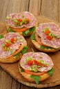 Ham sandwiches with chili, parsley and scallion on wooden board