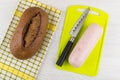 Ham sausage and knife on cutting board, loaf rye bread Royalty Free Stock Photo