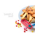 Hamantaschen cookies on plate and grogger on white background