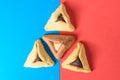 Hamantash filled-pocket cookie recognizable for triangular shape for Jewish holiday of Purim on red and blue background. Royalty Free Stock Photo