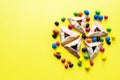 Hamantashen - traditional cookies for Jewish holiday Purim. Triangle cookies with assorted fillings on a yellow background