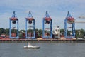 Hamburg, Germany, August 3, 2022: Pilot boat in front of the quay with containers and terminal cranes in the cargo port on the