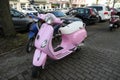 Vespa scooter light pink, side view, parked on the roadside in Hamburg