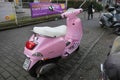 Vespa scooter light pink, side view, parked on the roadside in Hamburg
