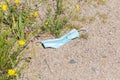 Used, blue face mask lying on the ground. Royalty Free Stock Photo