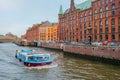 Hamburg, Germany - 25 October 2023: View on the brick buildings and a touristic boat on a canal in Kehrwieder in Hamburg