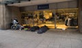 Hamburg. Homeless people sleep early in the morning on the street next to expensive shops in a sleeping ba