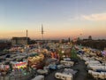 Wide Bird`s Eye View of large Fun Fair  `Hamburger Dom` with Roller Coaster, Carnival Rides and Hamburg Skyline at dusk Royalty Free Stock Photo