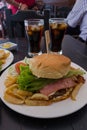 HAMBURGER ACCOMPANIED BY POTATOES AND BLACK SODA Royalty Free Stock Photo