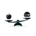 Hamburger and apple on scales. Balance between fast and healthy food