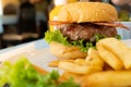 hamburger with bacon served in a white plate with french fries Royalty Free Stock Photo