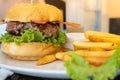 hamburger with bacon served in a white plate with french fries Royalty Free Stock Photo