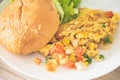 Hamburger bun And omelette with vegetables on a white plate