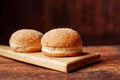 Hamburger buns. Sesame seeds on top. Wooden background. Food concept Royalty Free Stock Photo