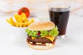 Hamburger Cheeseburger meal fastfood fast food with cola drink and French Fries on a wooden board Royalty Free Stock Photo