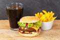 Hamburger Cheeseburger meal fastfood fast food with cola drink and French Fries on a wooden board Royalty Free Stock Photo