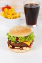 Hamburger Cheeseburger meal fastfood fast food with cola drink and French Fries on a wooden board portrait format Royalty Free Stock Photo