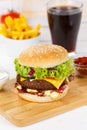 Hamburger Cheeseburger meal fastfood fast food with cola drink and French Fries on a wooden board portrait format Royalty Free Stock Photo