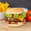 Hamburger Cheeseburger meal fastfood fast food with French Fries on a wooden board square Royalty Free Stock Photo