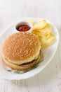 Hamburger with chips and sauce on white dish Royalty Free Stock Photo