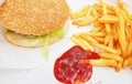 Hamburger classic burger american cheeseburger with cheese, bacon, tomato, lettuce and french fries, fried potatoes with ketchup Royalty Free Stock Photo