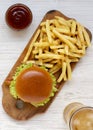 Hamburger, french fries, bbq sauce and glass of cold beer on a white wooden background, top view. Overhead, flat lay, from above Royalty Free Stock Photo