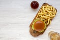 Hamburger, french fries, bbq sauce and glass of cold beer on a white wooden background, top view. Overhead, flat lay, from above. Royalty Free Stock Photo