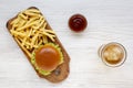 Hamburger, french fries, bbq sauce and glass of cold beer on a white wooden table, top view. Overhead, flat lay, from above Royalty Free Stock Photo