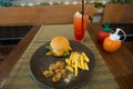 Hamburger, french fries, chicken Kara Kay on a black plate. Royalty Free Stock Photo