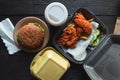 Hamburger, french fries and fried chicken in takeaway containers on the wooden background. Food delivery and fast food concept Royalty Free Stock Photo