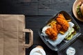 Hamburger, french fries and fried chicken in takeaway containers on the wooden background. Food delivery and fast food concept Royalty Free Stock Photo