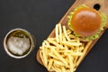 Hamburger, french fries and glass of cold beer on a black background, top view. Flat lay, from above, overhead. Copy space Royalty Free Stock Photo