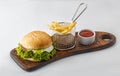 hamburger with french fries and ketchup on a wooden board isolated on white background Royalty Free Stock Photo