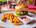 Hamburger, french fries, mayonnaise and ketchup on restaurant background. Yummy fresh burger and french fries Royalty Free Stock Photo