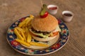 Hamburger with french fries in plate with ornaments Royalty Free Stock Photo