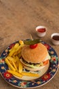 Hamburger with french fries in plate with ornaments