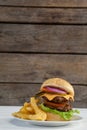 Hamburger and french fries in plate on wooden table Royalty Free Stock Photo