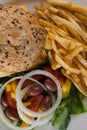 Hamburger, french fries, and salad in plate on table Royalty Free Stock Photo