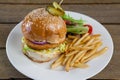 Hamburger, french fries and salad in plate on wooden table Royalty Free Stock Photo