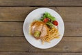 Hamburger, french fries and salad in plate on wooden table Royalty Free Stock Photo