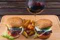 Hamburger and french fries on a wooden plate. Royalty Free Stock Photo