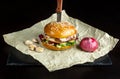 Hamburger with garlic is on kraft paper. Bottom of the black slate. Royalty Free Stock Photo